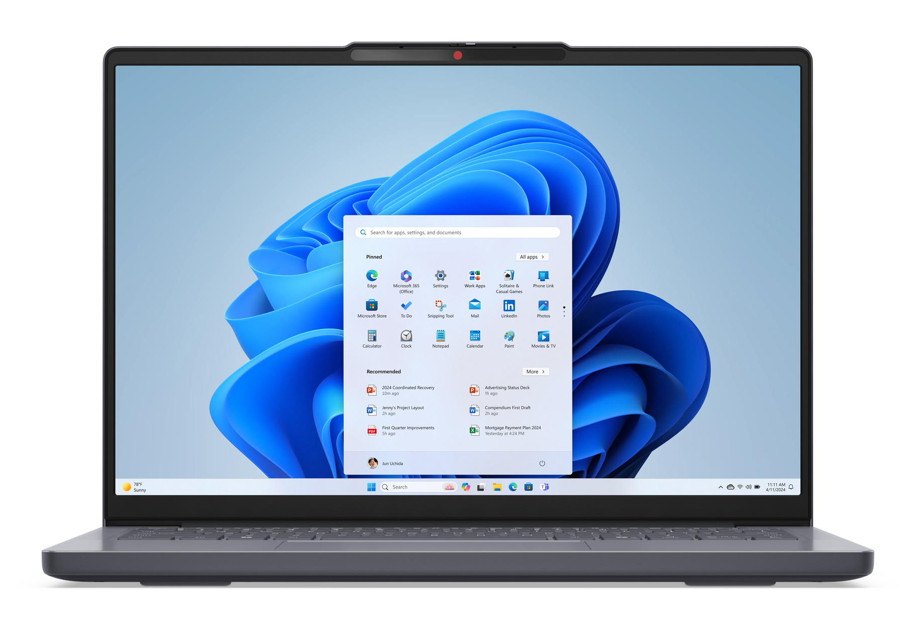 Ein Laptop zeigt den blauen Windows 11-Startbildschirm und die Taskleiste.