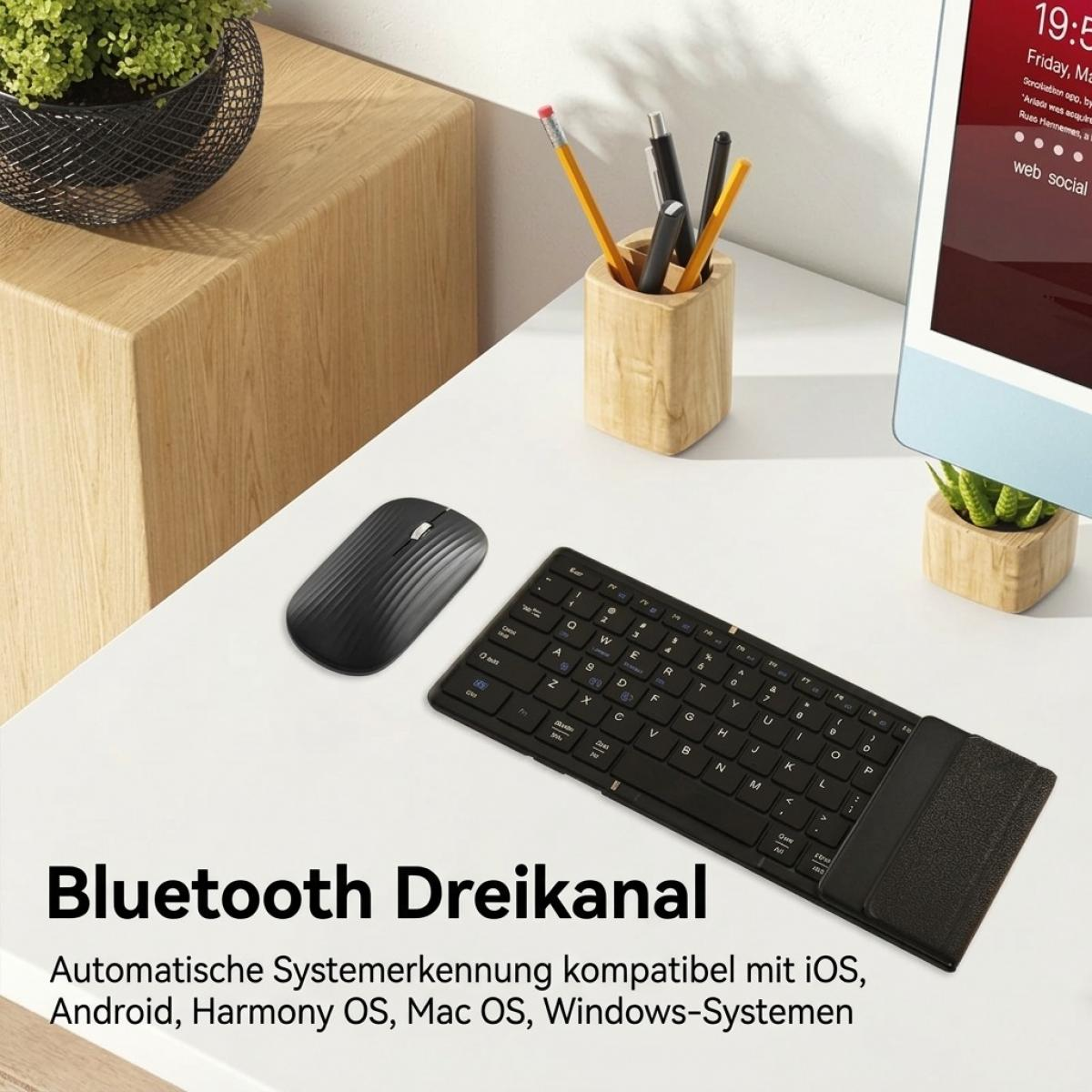 Schwarze Tastatur und Maus auf weißem Schreibtisch mit Stiftehalter und Pflanzen.