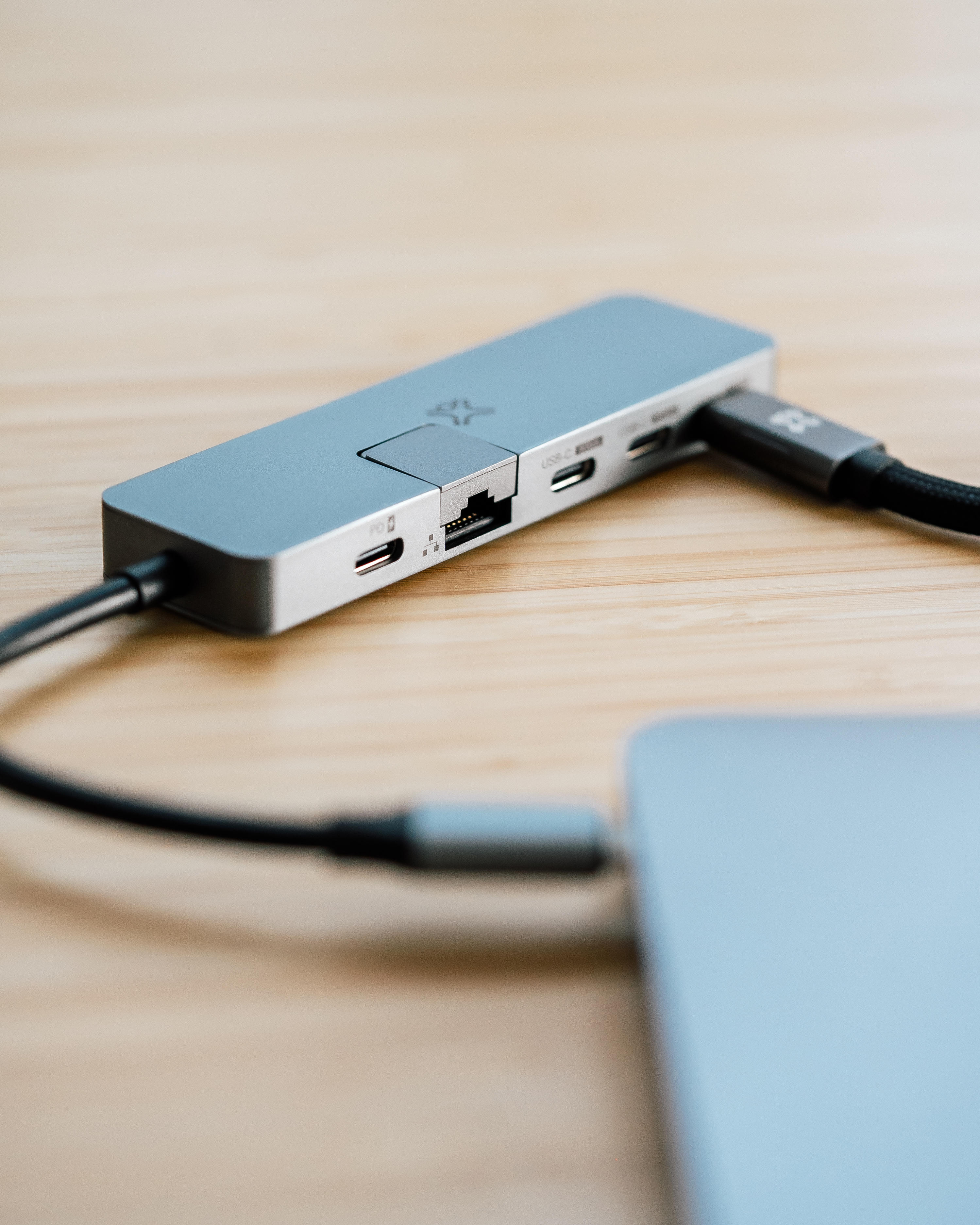 Un hub USB-C grigio con varie porte collegato a un computer portatile.