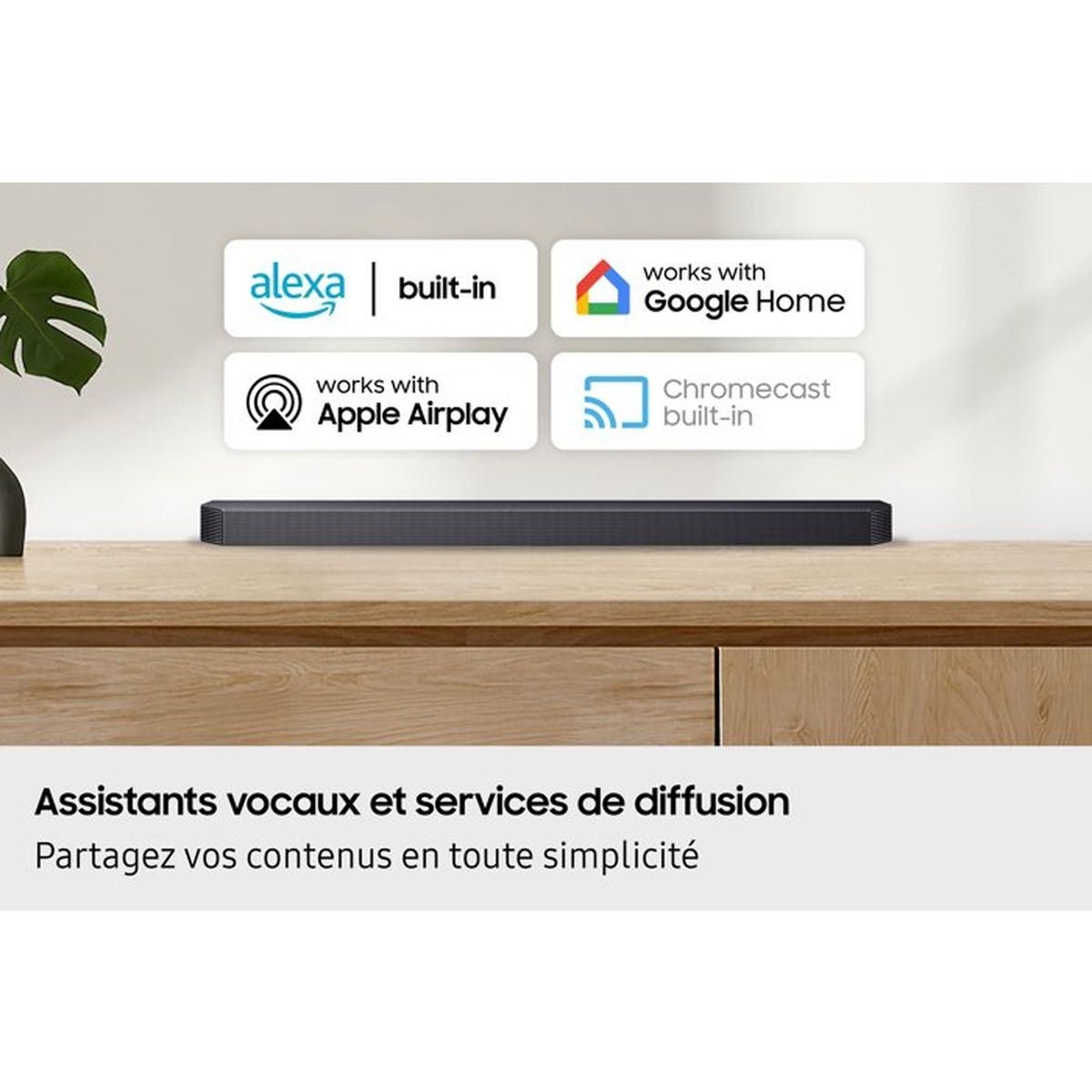 Eine Soundbar auf einem Holzmöbel mit Logos für Alexa, Google Home, Apple Airplay und Chromecast.