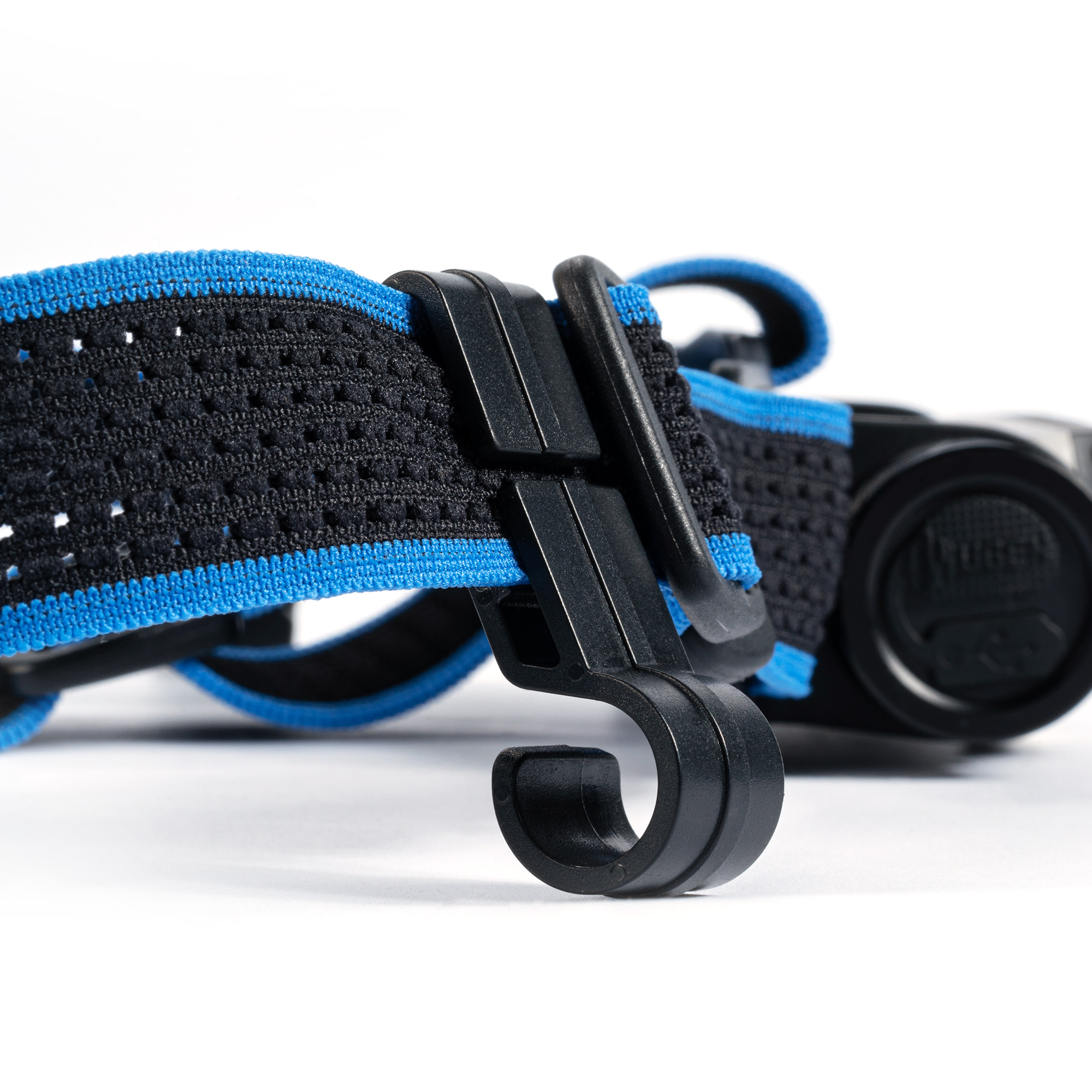 Ein blauschwarzes elastisches Stirnband mit einer schwarzen Plastikhalterung auf weißem Hintergrund.