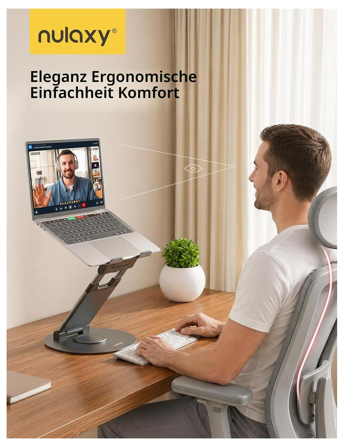 Ein Mann sitzt an einem Holztisch vor einem Laptop auf einem ergonomischen Ständer.