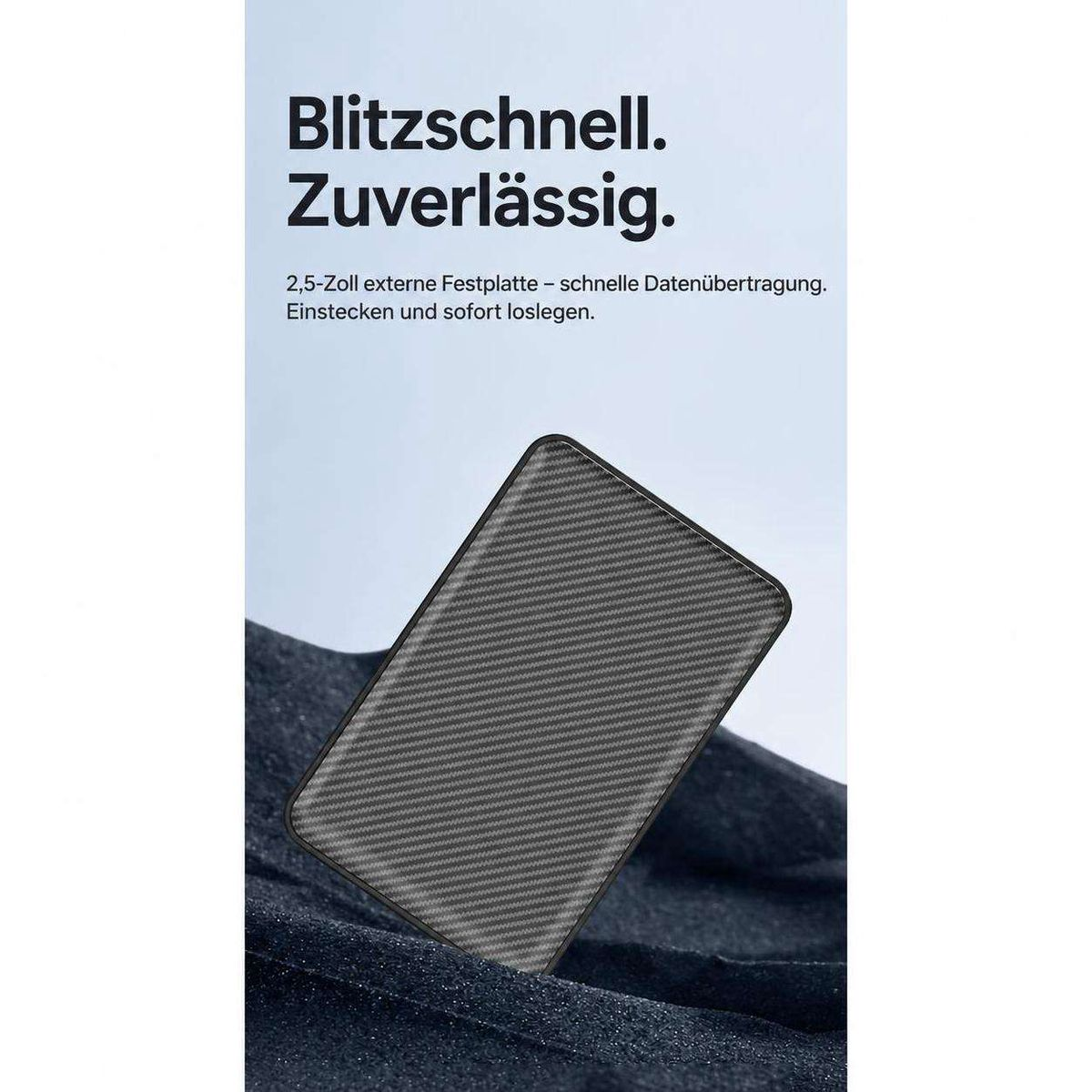 Eine schwarze externe Festplatte liegt auf dunkelblauem Stoff vor weißem Hintergrund mit Text.