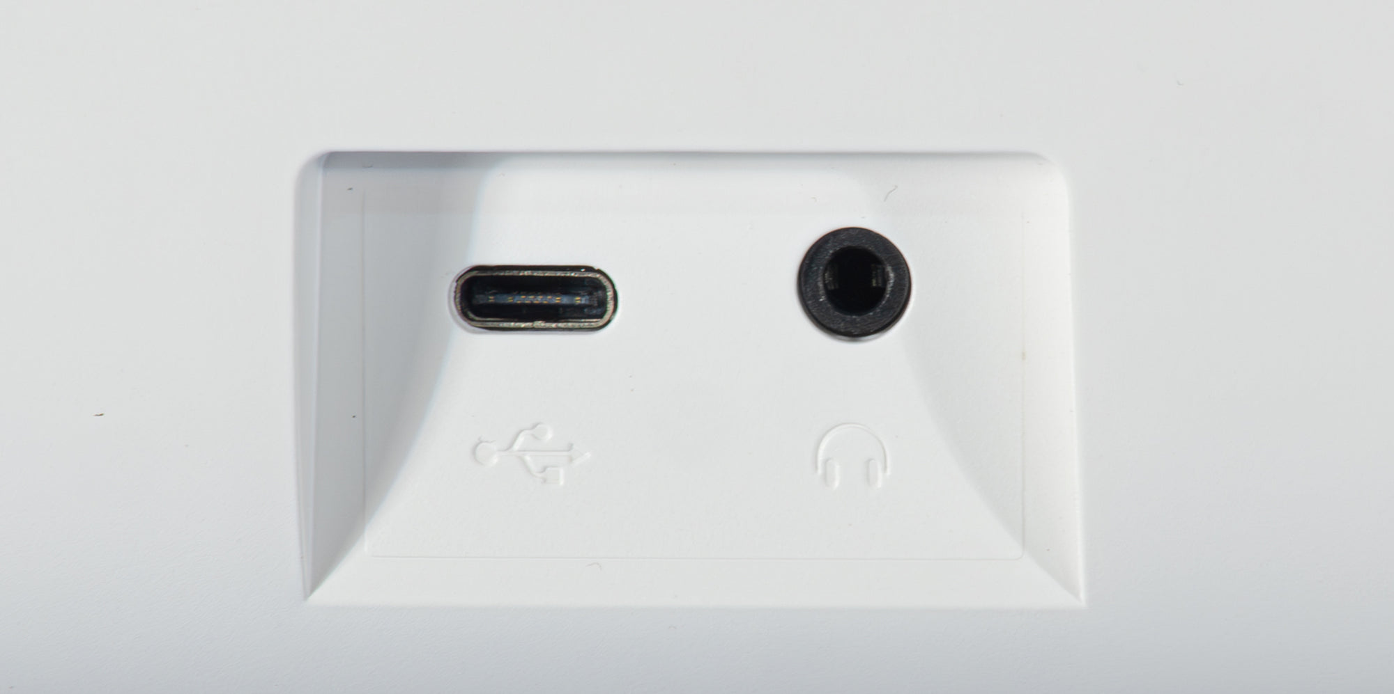 Nahaufnahme einer weißen Gerätevorderseite mit einem USB-C-Anschluss und einer Kopfhörerbuchse.