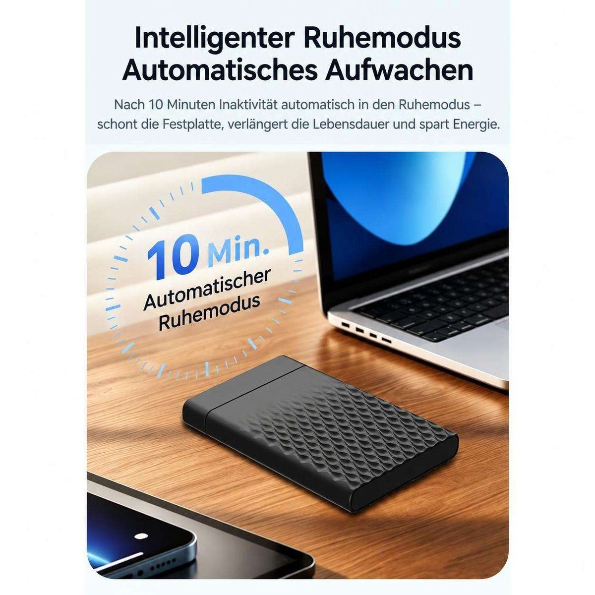 Eine schwarze externe Festplatte auf einem Holztisch mit Laptop und Smartphone im Hintergrund sowie Text.
