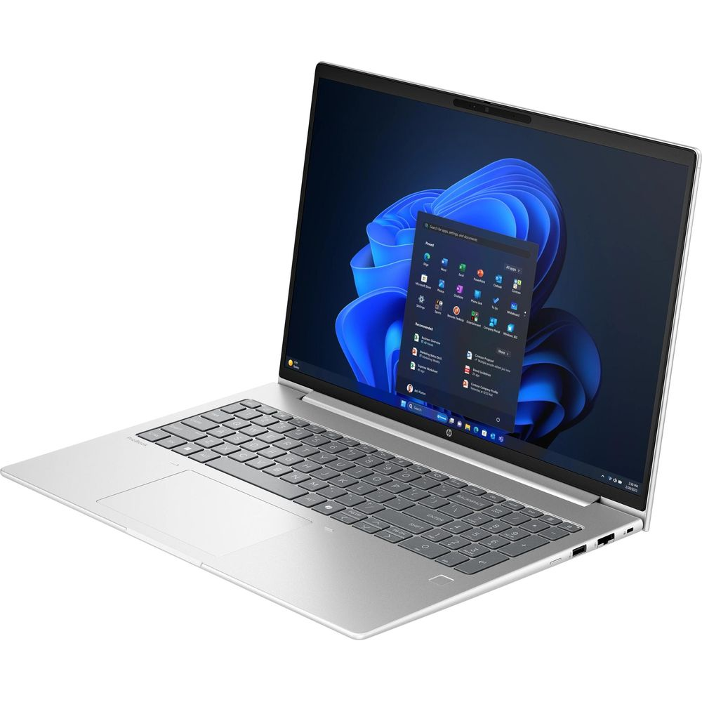 Un ordinateur portable argenté avec un clavier noir et un fond d'écran Windows bleu à l'écran.