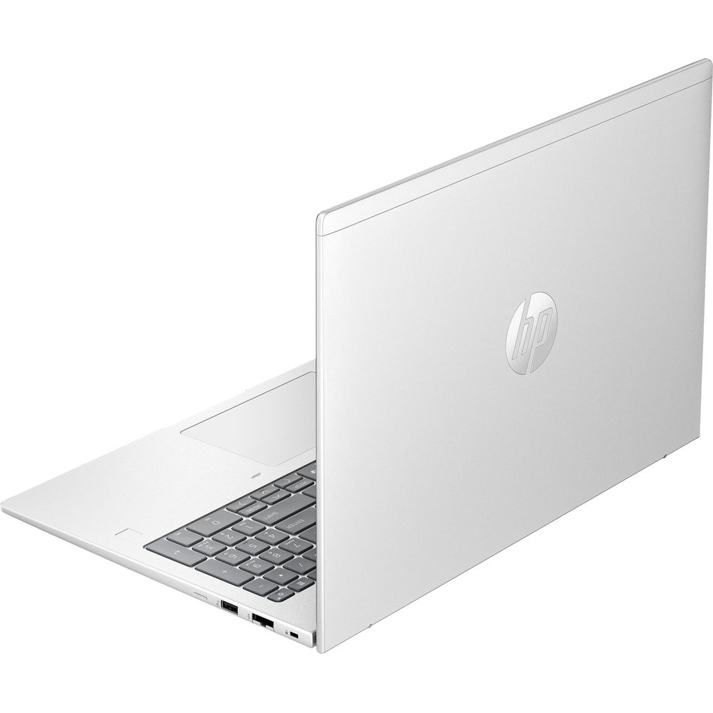 Un ordinateur portable HP argenté sur une surface plane, vu de l'arrière droit, montrant son clavier et ses ports.