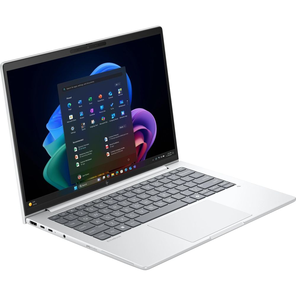 Un laptop argentato con lo schermo aperto mostra il menu Start di Windows e uno sfondo colorato.