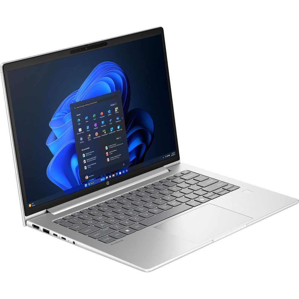 Ordinateur portable argenté avec écran bleu illuminé et clavier gris sur fond blanc.