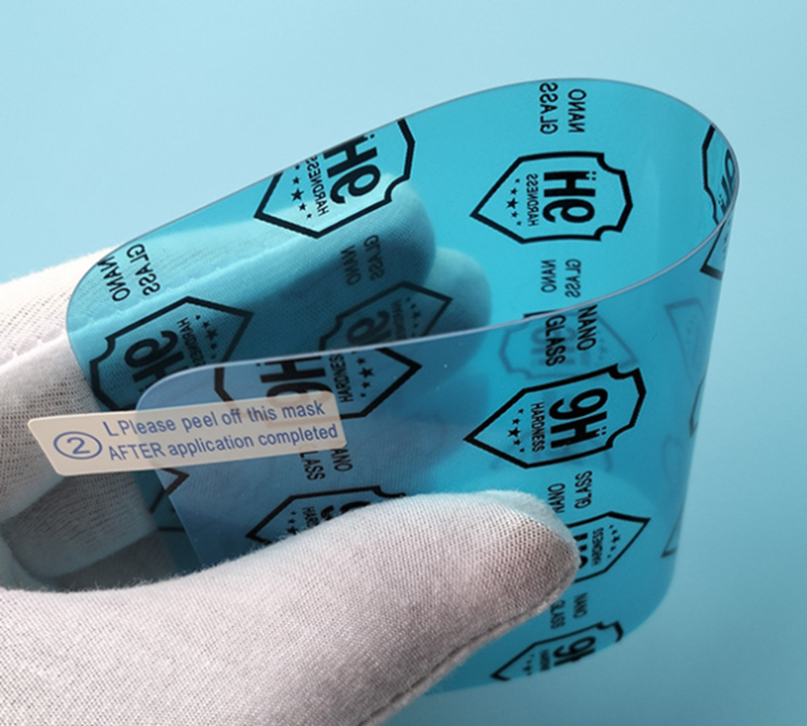 Eine Hand in einem weißen Handschuh hält eine blaue Schutzfolie mit schwarzen Logos vor einem blauen Hintergrund.
