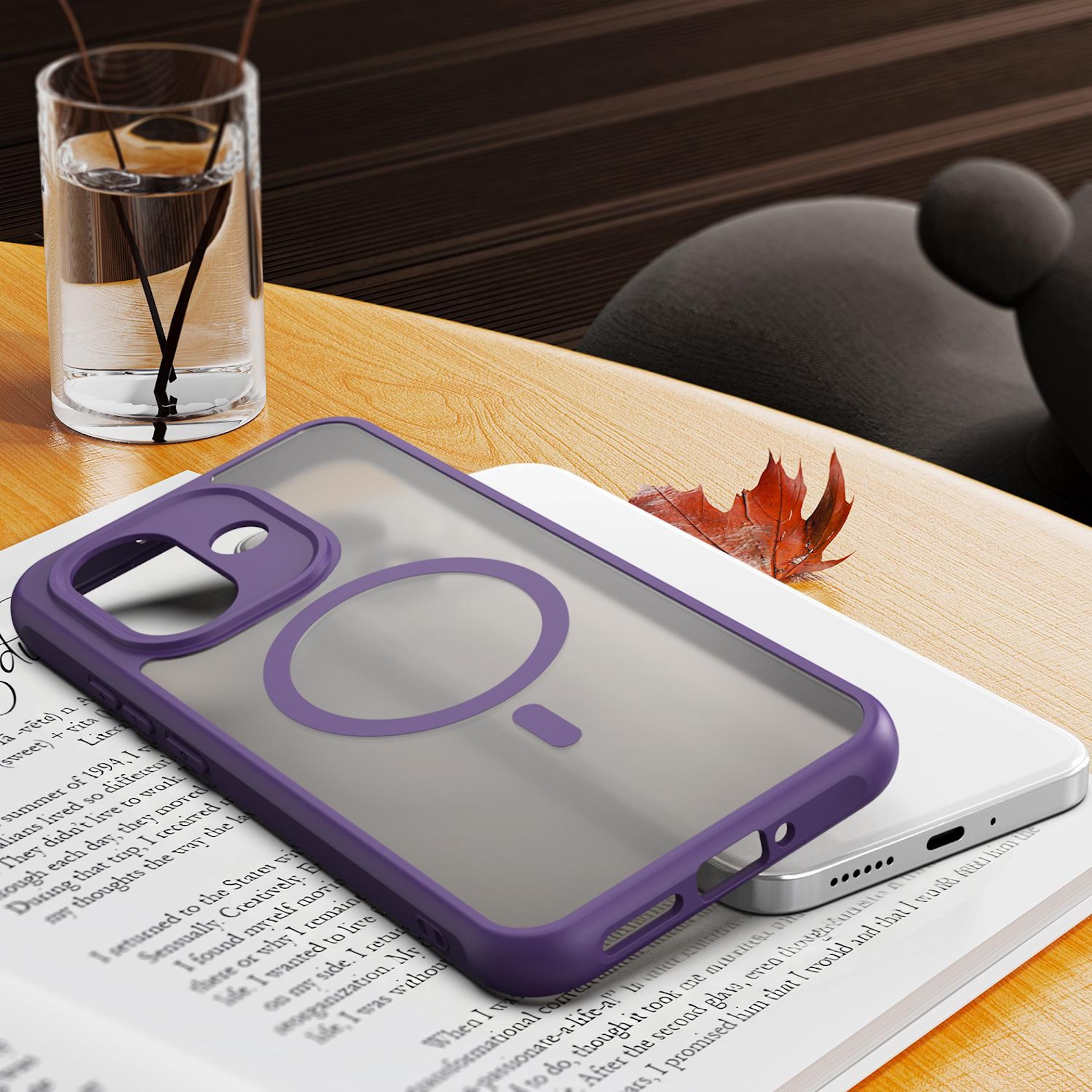 Eine lila Smartphone-Hülle liegt auf einem Buch auf einem Holztisch, daneben ein Glas Wasser.