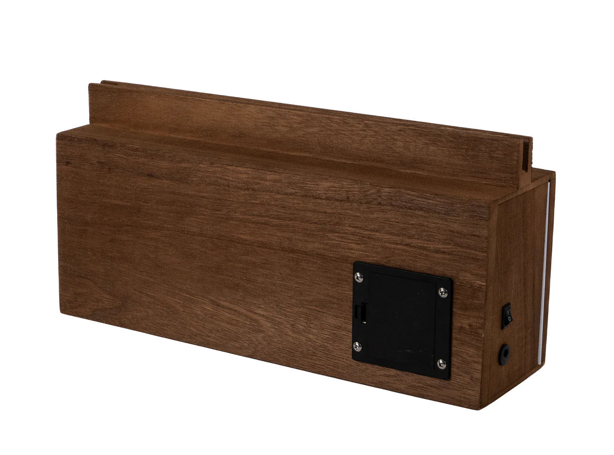 Eine rechteckige Holzbox mit schwarzem Batteriefach, Schalter und Anschluss an der Seite.