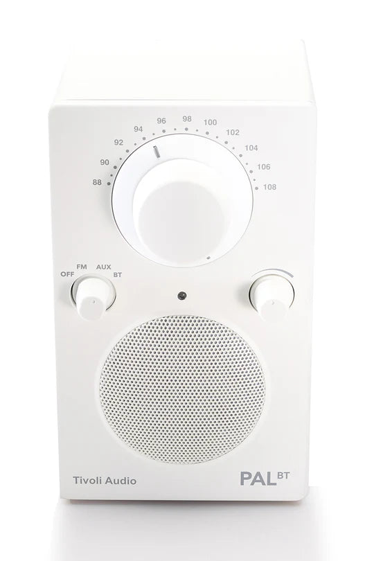 Ein weißes Tivoli Audio PAL BT Radio mit einem großen Tuning-Knopf, kleineren Reglern und einem runden Lautsprecher.