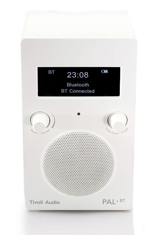 Ein weißes Tivoli Audio PAL+ BT Radio mit Display, Lautsprecher und zwei Knöpfen auf weißem Hintergrund.