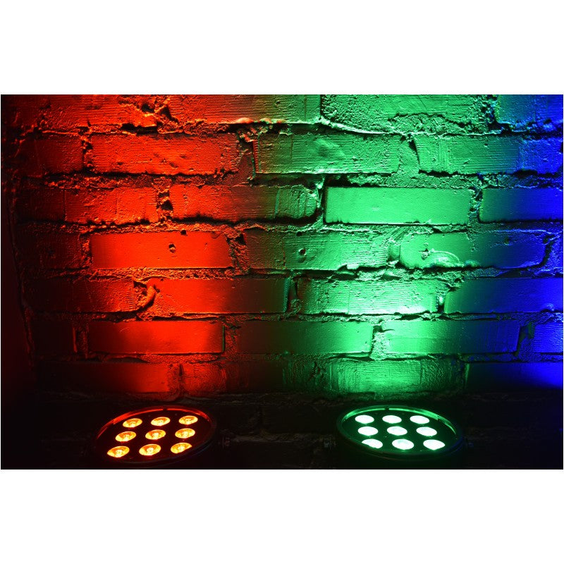 Zwei Bühnenlichter beleuchten eine strukturierte Ziegelmauer in Rot, Grün und Blau.