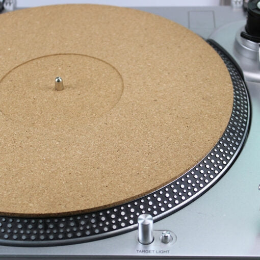 Ein runder, brauner Kork-Plattenteller auf einem silbernen DJ-Plattenspieler.