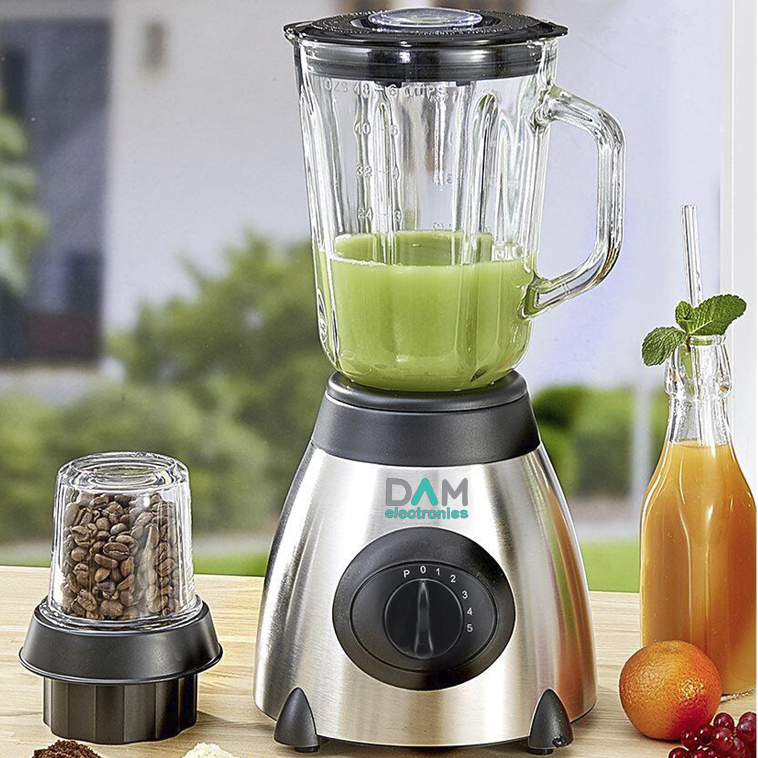 Una licuadora plateada con batido verde en un mostrador junto a granos de café, jugo de naranja y una fruta.