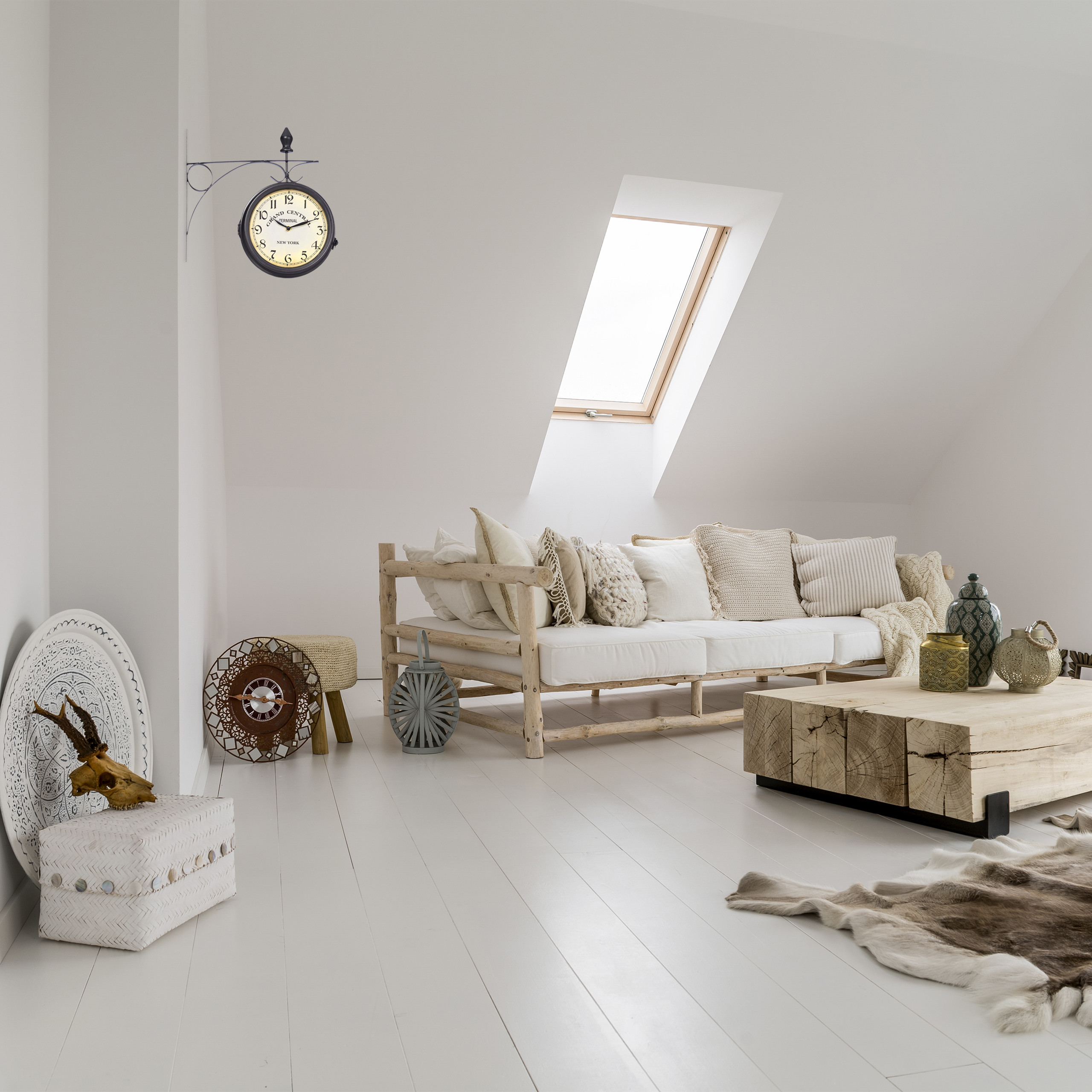 Gemütliches Dachzimmer mit Holzbett, Holztisch, Wanduhr und schrägen Fenstern.