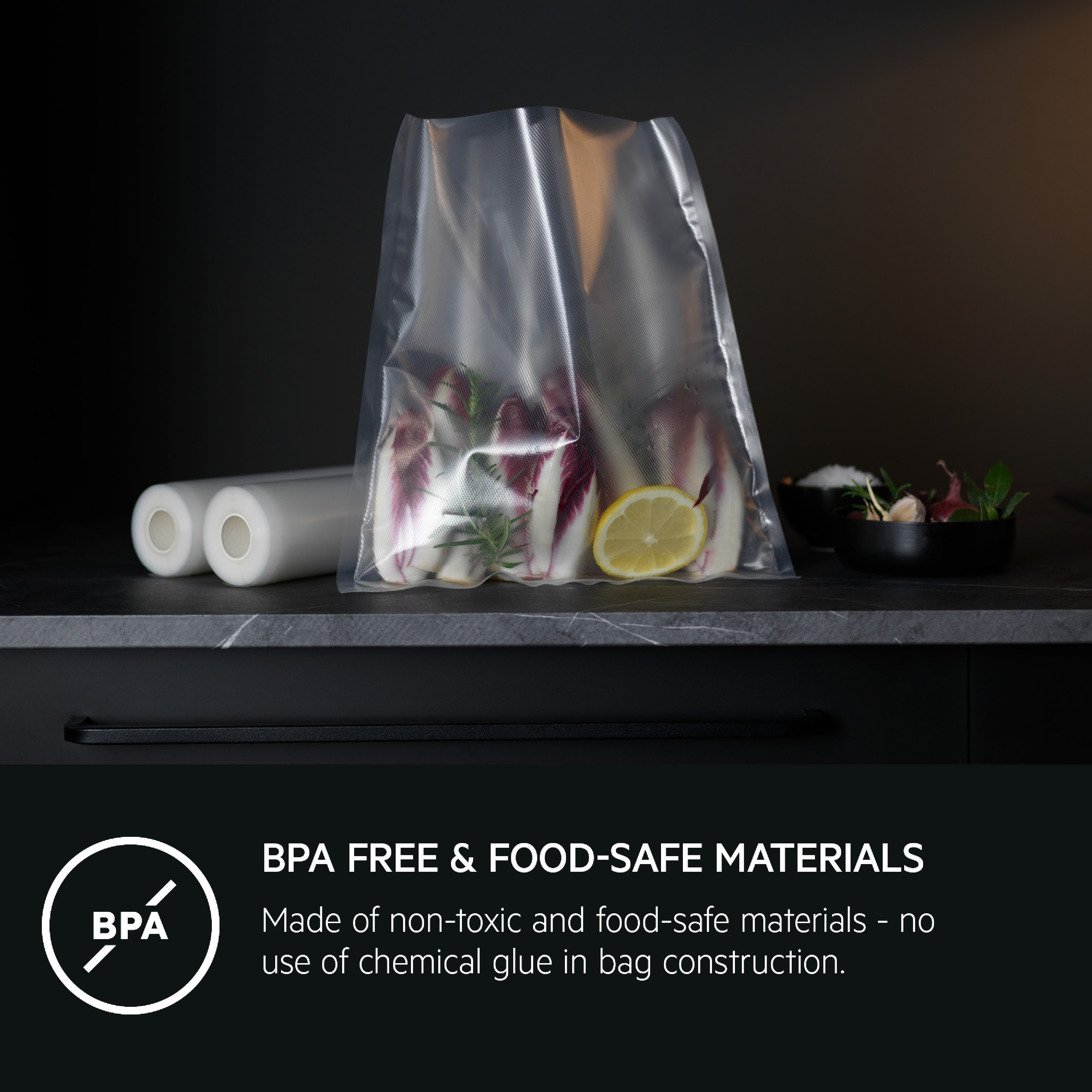 Bolsa de vacío apta para alimentos con achicoria y limón, además de dos rollos en la encimera oscura.