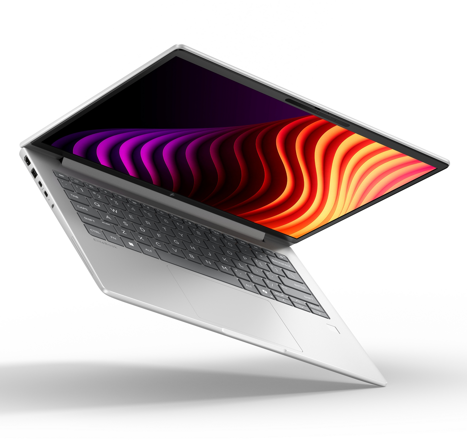 Un computer portatile argentato inclinato su sfondo bianco, con uno sfondo astratto a onde viola e arancioni.