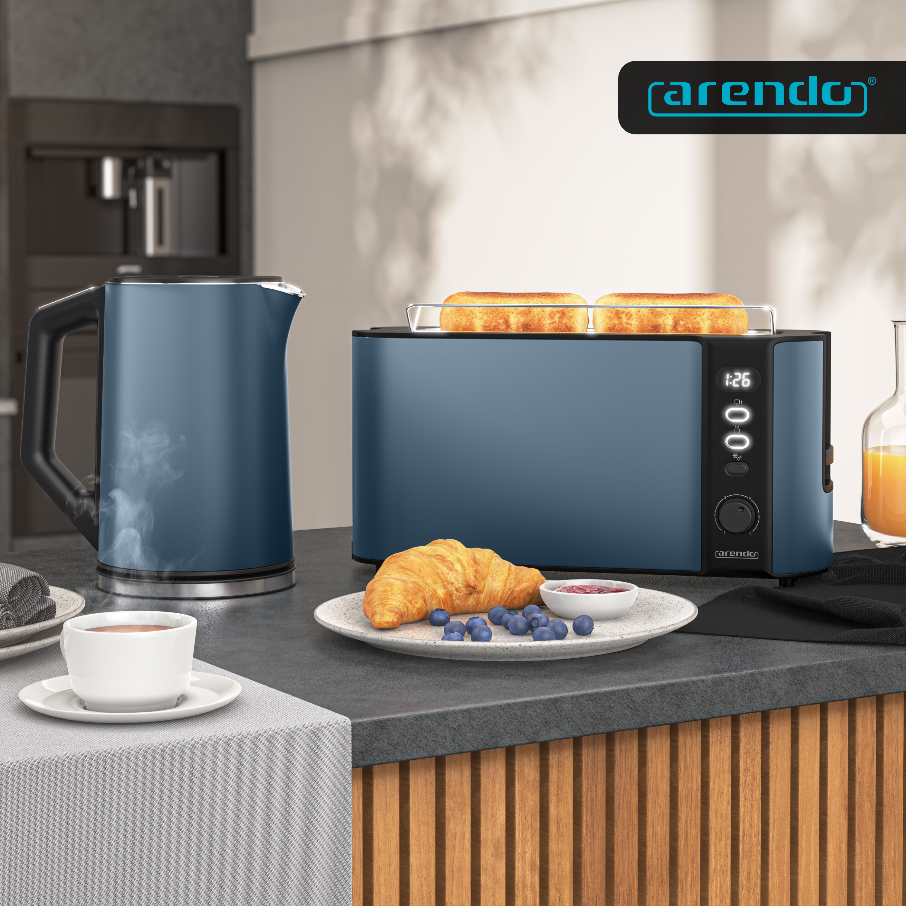 Blaue Arendo Küchengeräte mit Toaster, Wasserkocher, Croissant und Blaubeeren auf einer Küchenzeile.