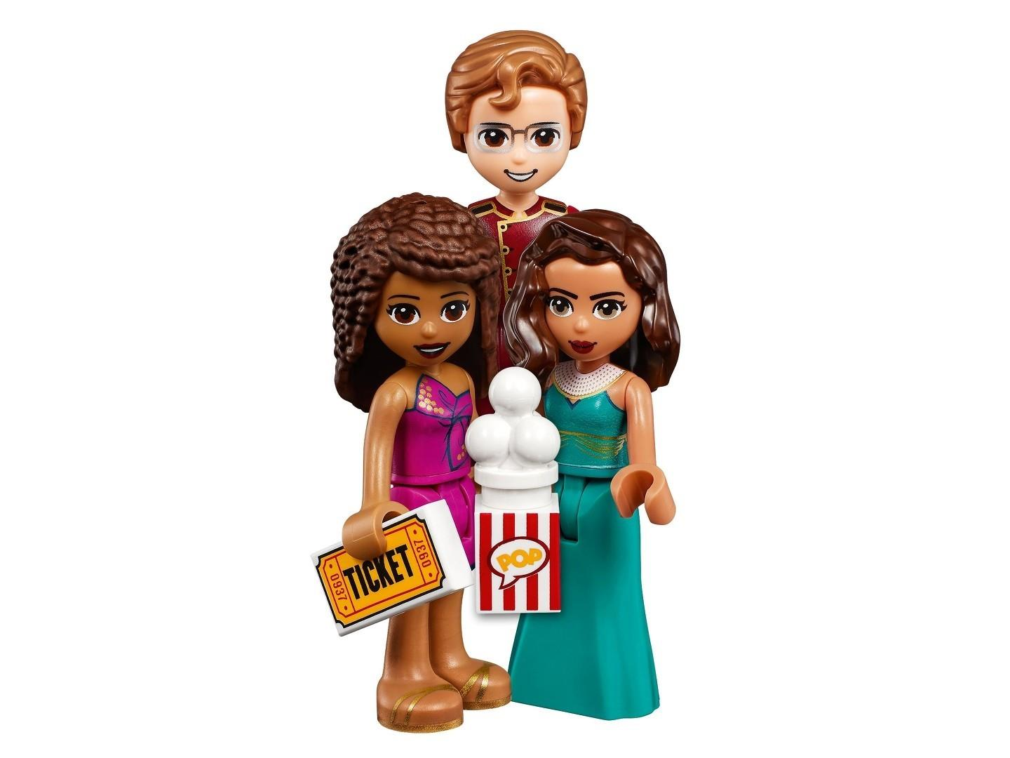 Drei Lego Friends Figuren halten eine Eintrittskarte und Popcorn vor einem weißen Hintergrund.