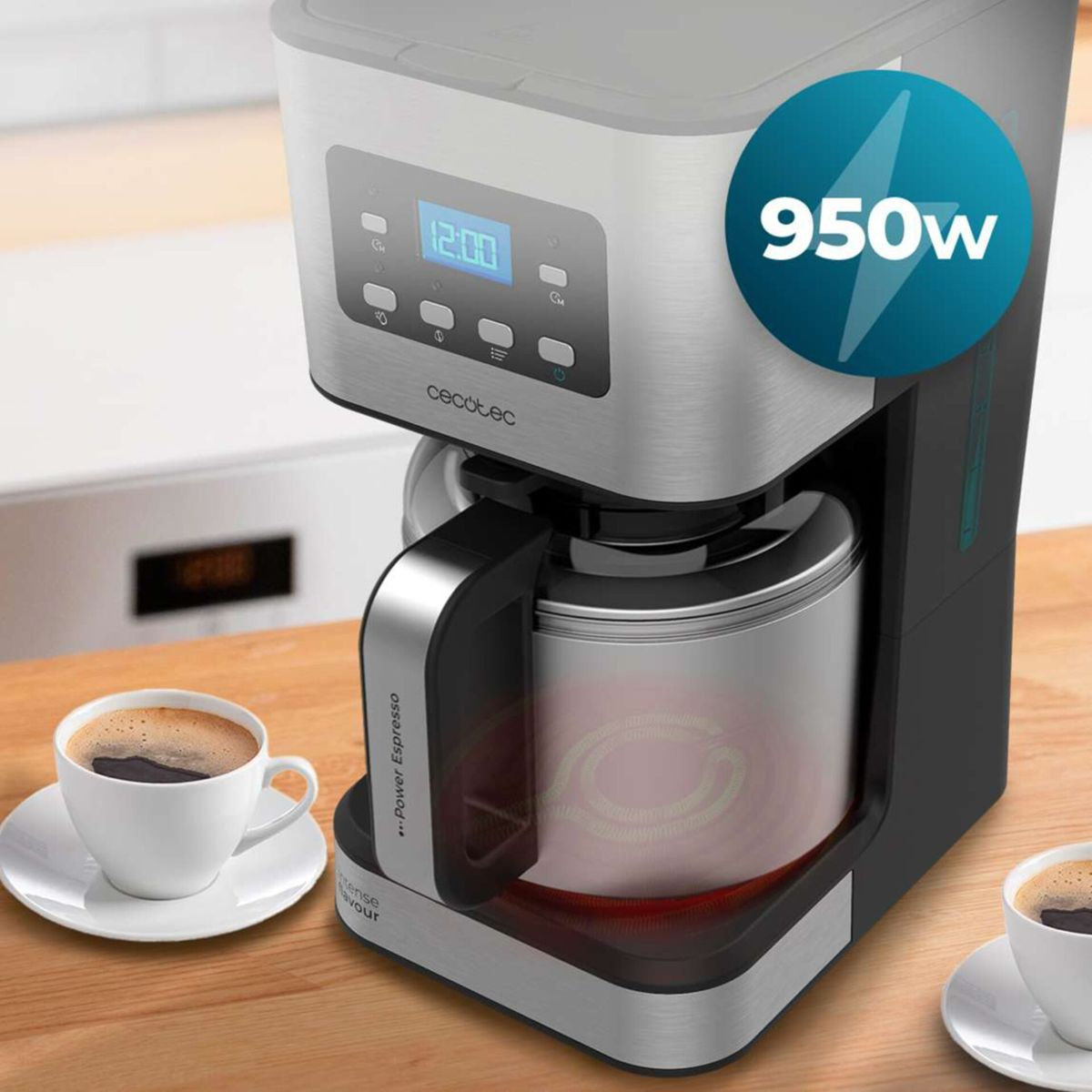 Una macchina da caffè a filtro argento e nera su un bancone di legno con due tazze di caffè e un badge da 950w.