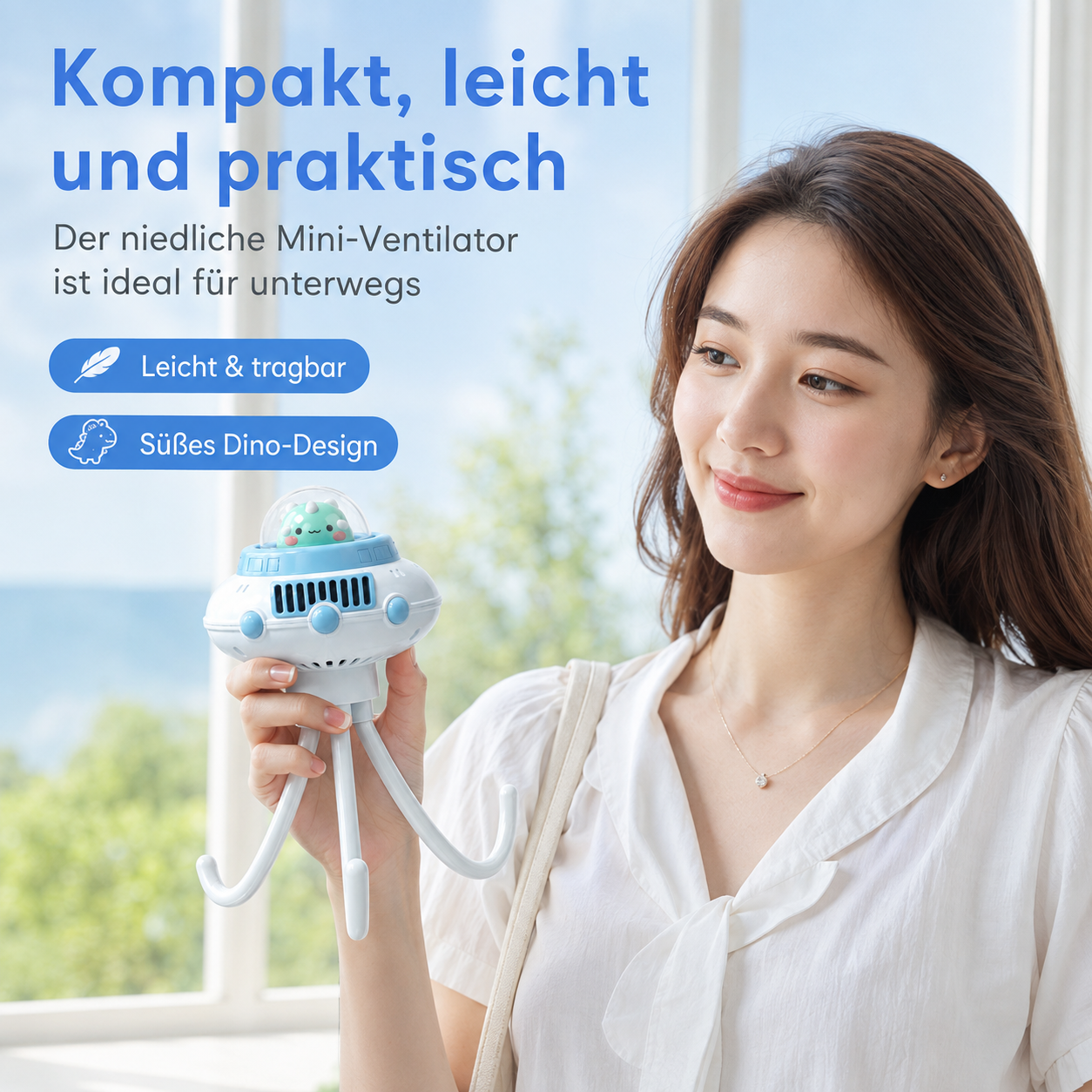 Eine Frau hält einen kleinen, blauen UFO-Ventilator mit flexiblen Beinen vor ein Fenster.