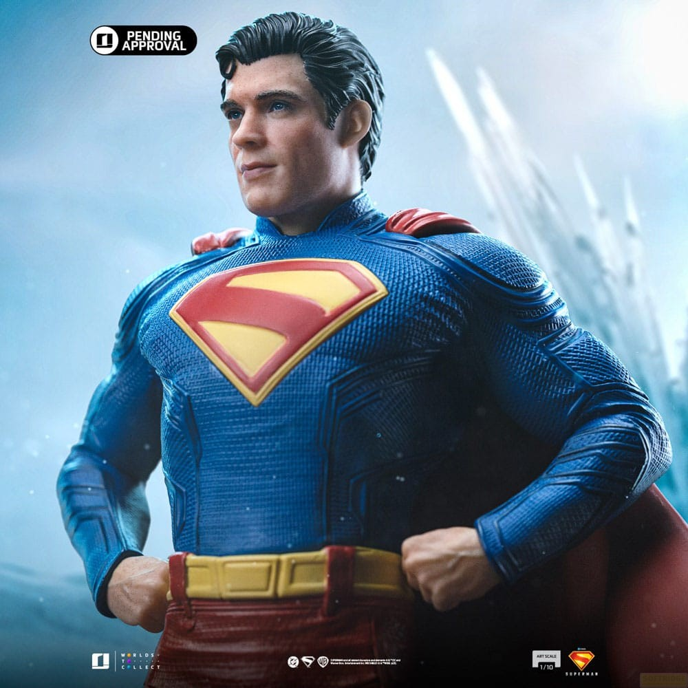 Action figure di Superman in tuta blu testurizzata e mantello rosso su sfondo sfocato.