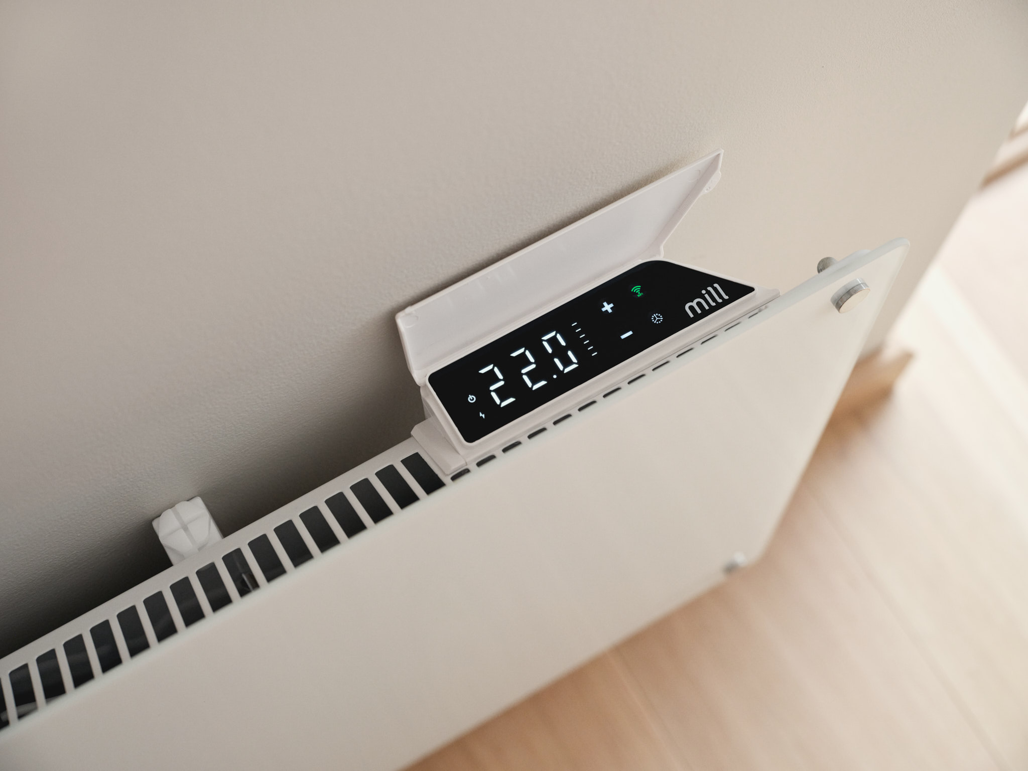 Una stufa a parete Mill bianca con display digitale che mostra 22 gradi.