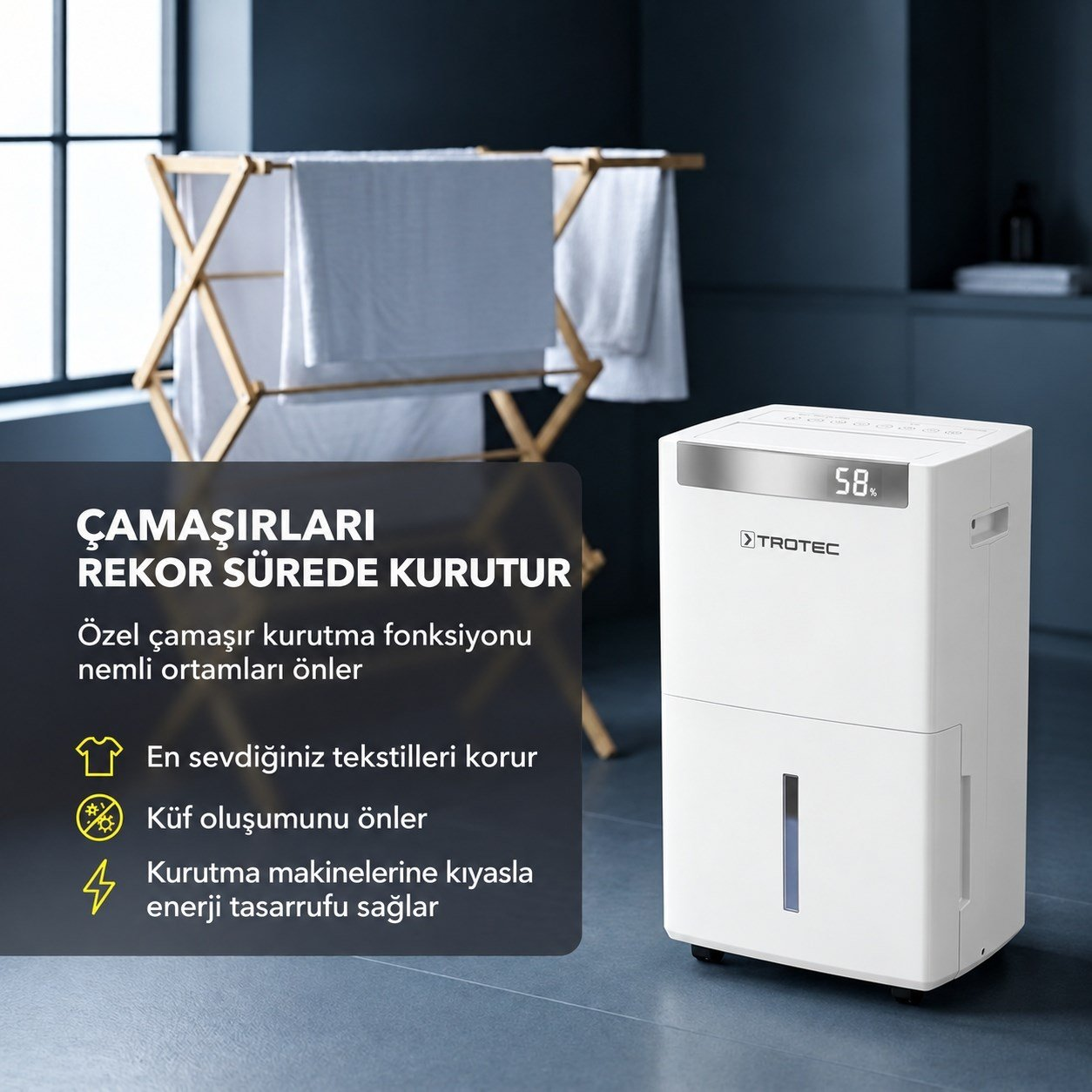 Arka planda çamaşır kurutmalığı olan zeminde beyaz bir Trotec nem alma cihazı duruyor.