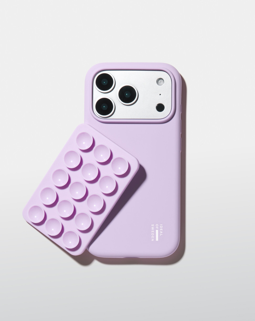 Eine hellviolette Handytasche mit einer passenden Saugnapf-Halterung liegt vor einem weißen Hintergrund.