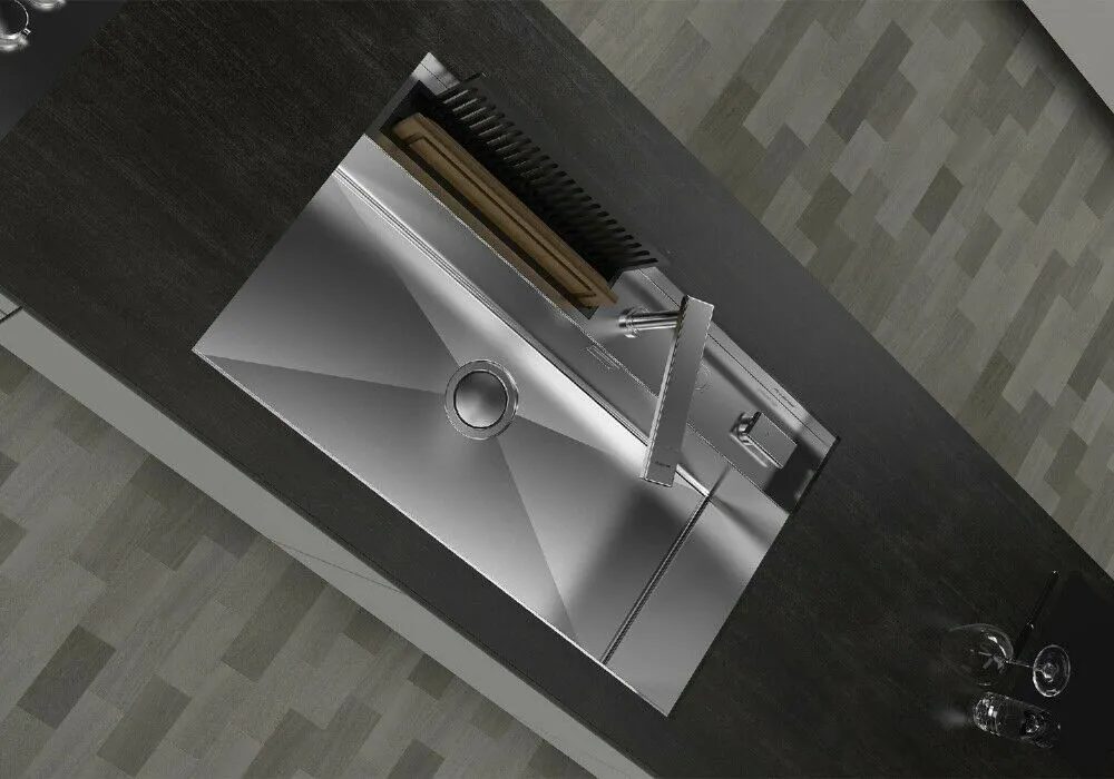 Un moderno lavello in acciaio inox su un piano di lavoro scuro, con rubinetto e tagliere.