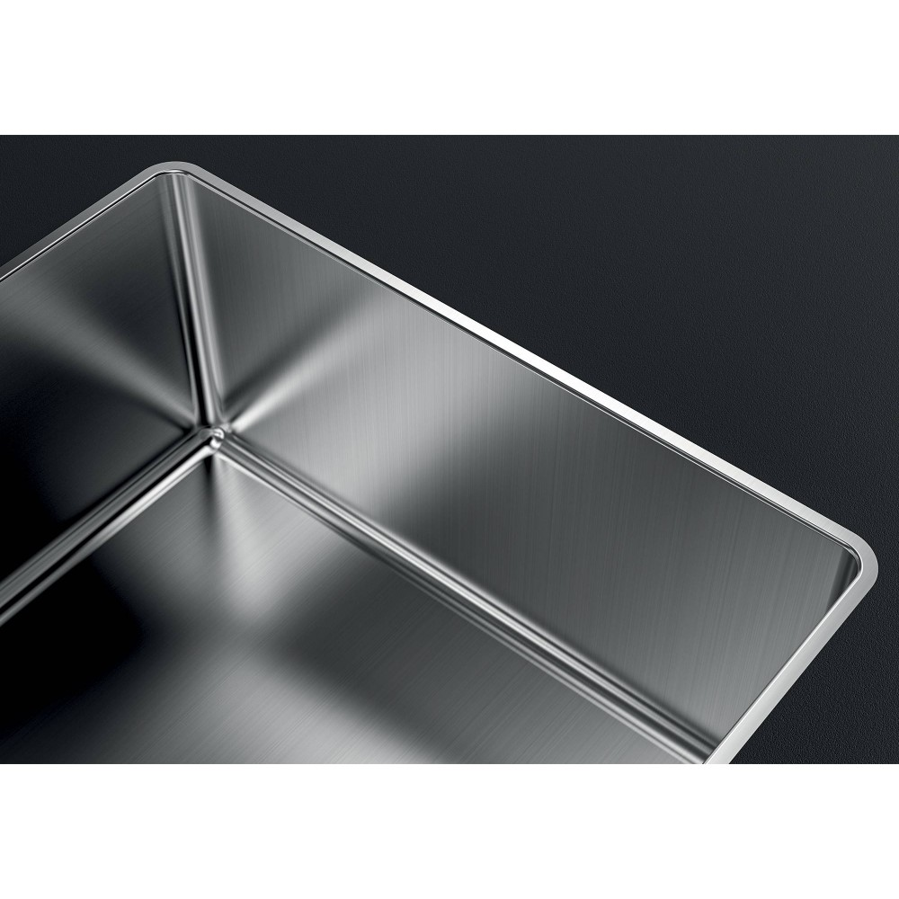 Angolo di un lavello quadrato in acciaio inox su piano di lavoro scuro.