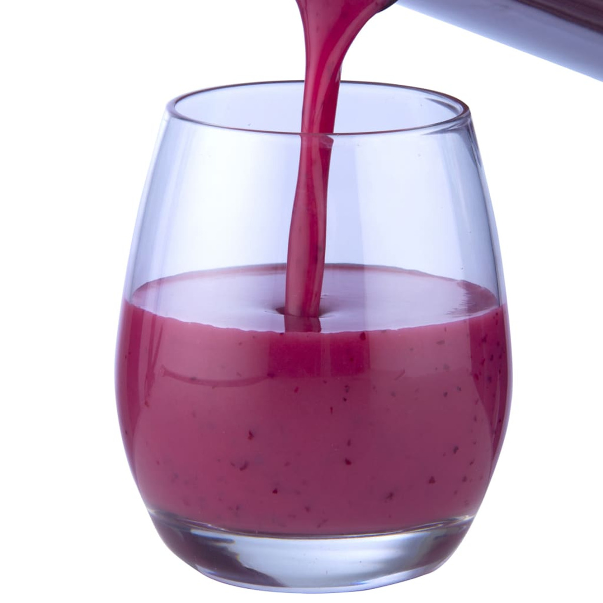 Ein Glas wird mit einem dickflüssigen, violetten Beerensaft gefüllt vor weißem Hintergrund.