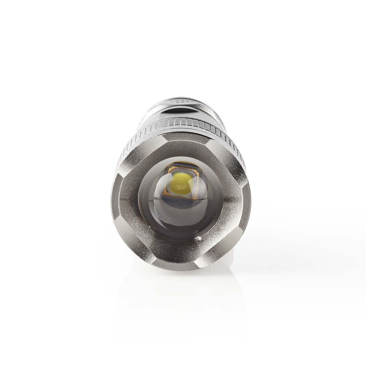 Vista frontale di una torcia argentata con lente LED su sfondo bianco.