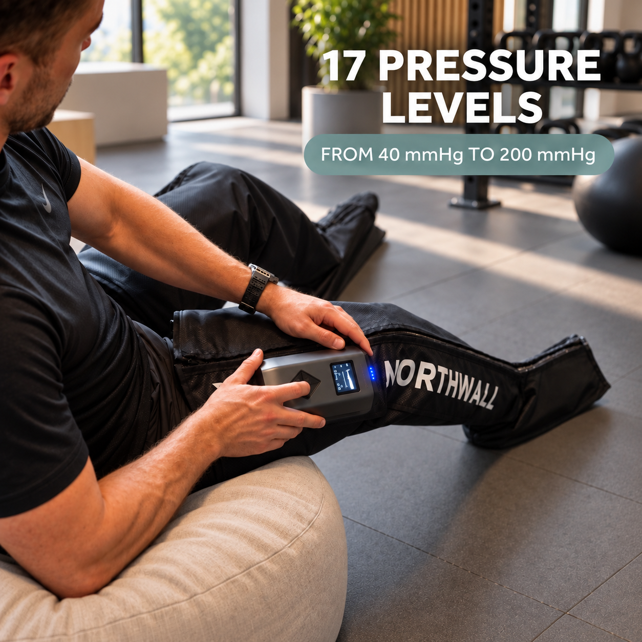 Un homme en tenue de sport assis sur un coussin utilise un appareil de compression des jambes Northwall.