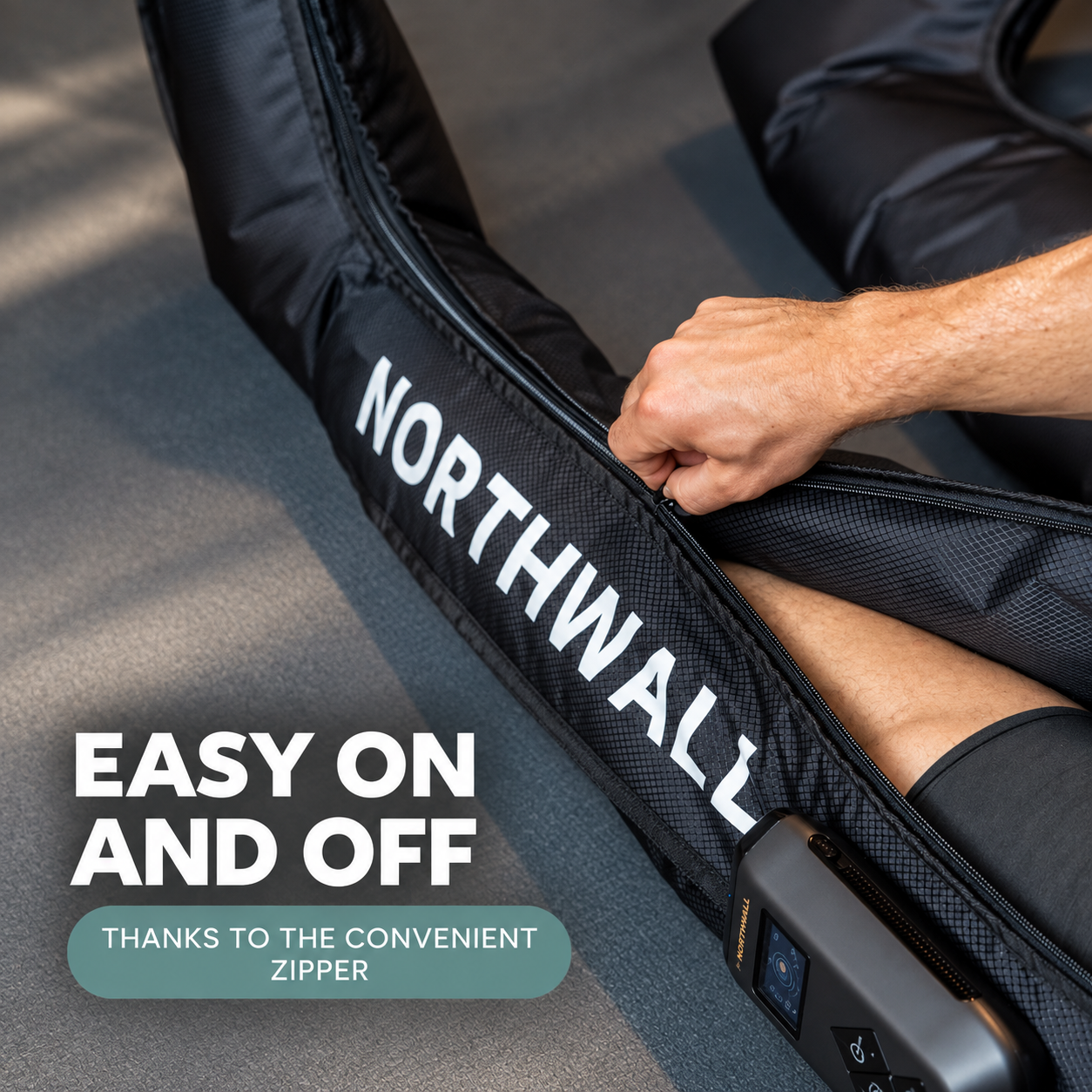 Une main ferme la fermeture éclair d'une manette de compression noire Northwall pour jambe.
