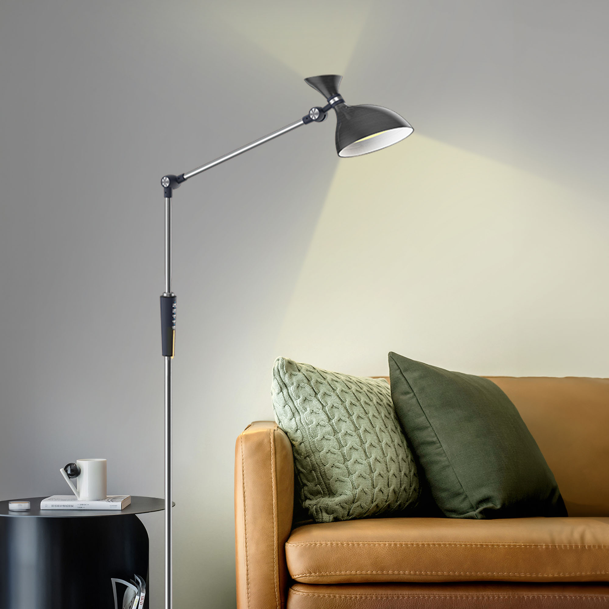 Czarna lampa podłogowa oświetla brązową skórzaną sofę z poduszkami i mały stolik.