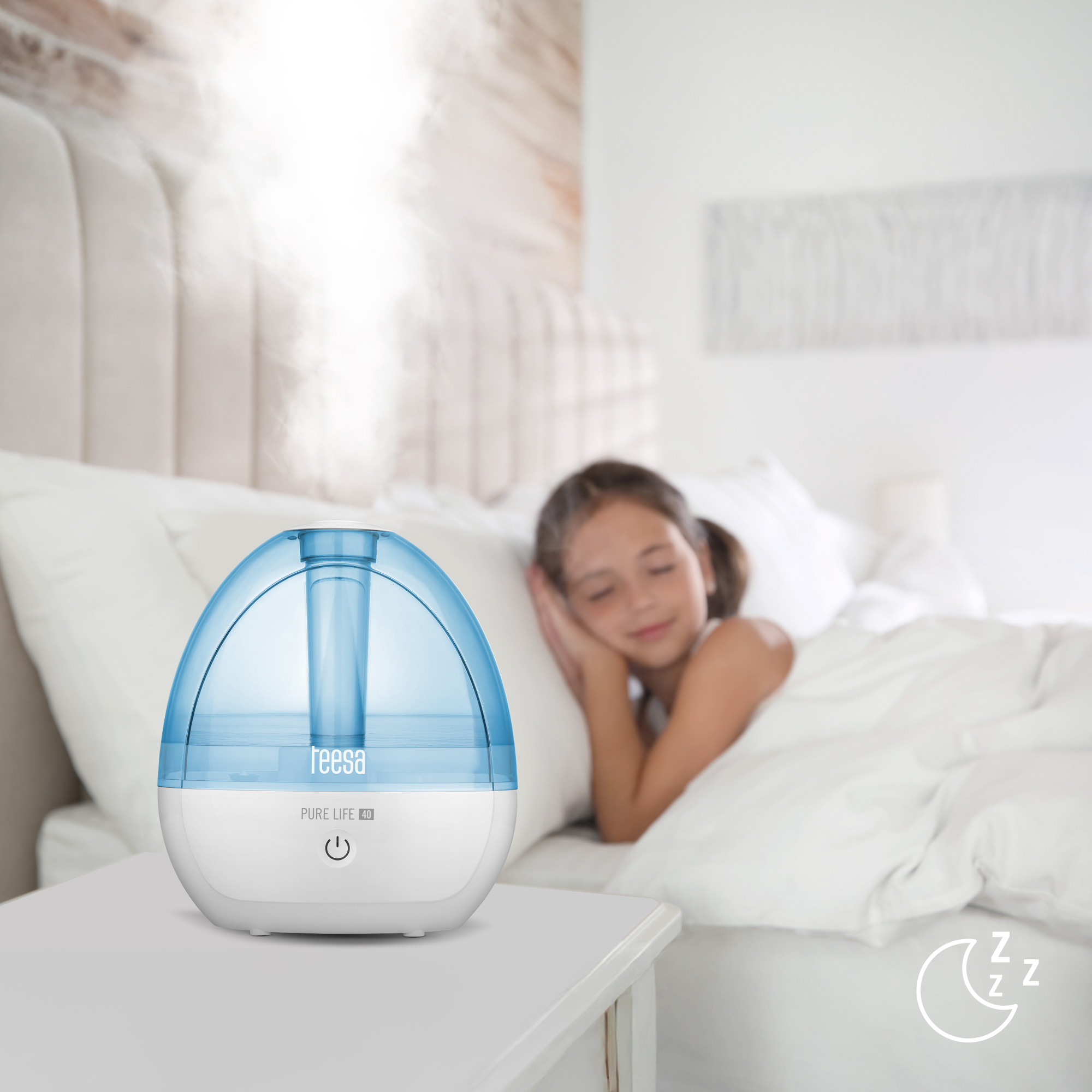 Egy kék párásító áll az éjjeliszekrényen, miközben egy gyermek alszik az ágyban.