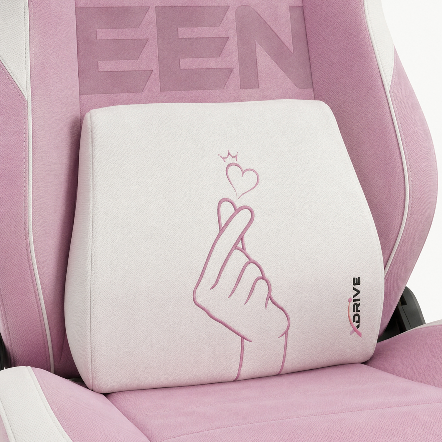 Pembe ve beyaz oyuncu koltuğunda pembe kalp el işaretli beyaz bir yastık.