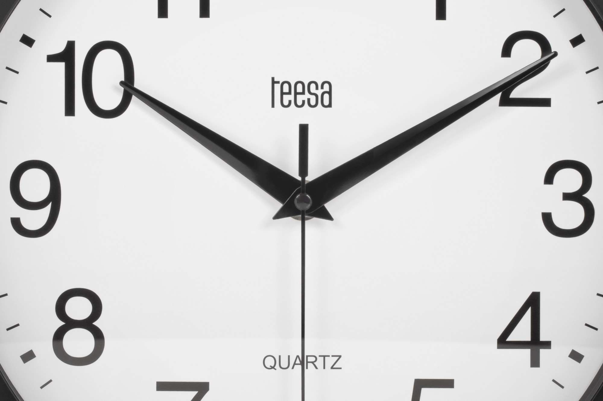 Biały zegar Teesa Quartz z czarnymi cyframi i wskazówkami pokazującymi prawie dziesięć po dziesiątej.