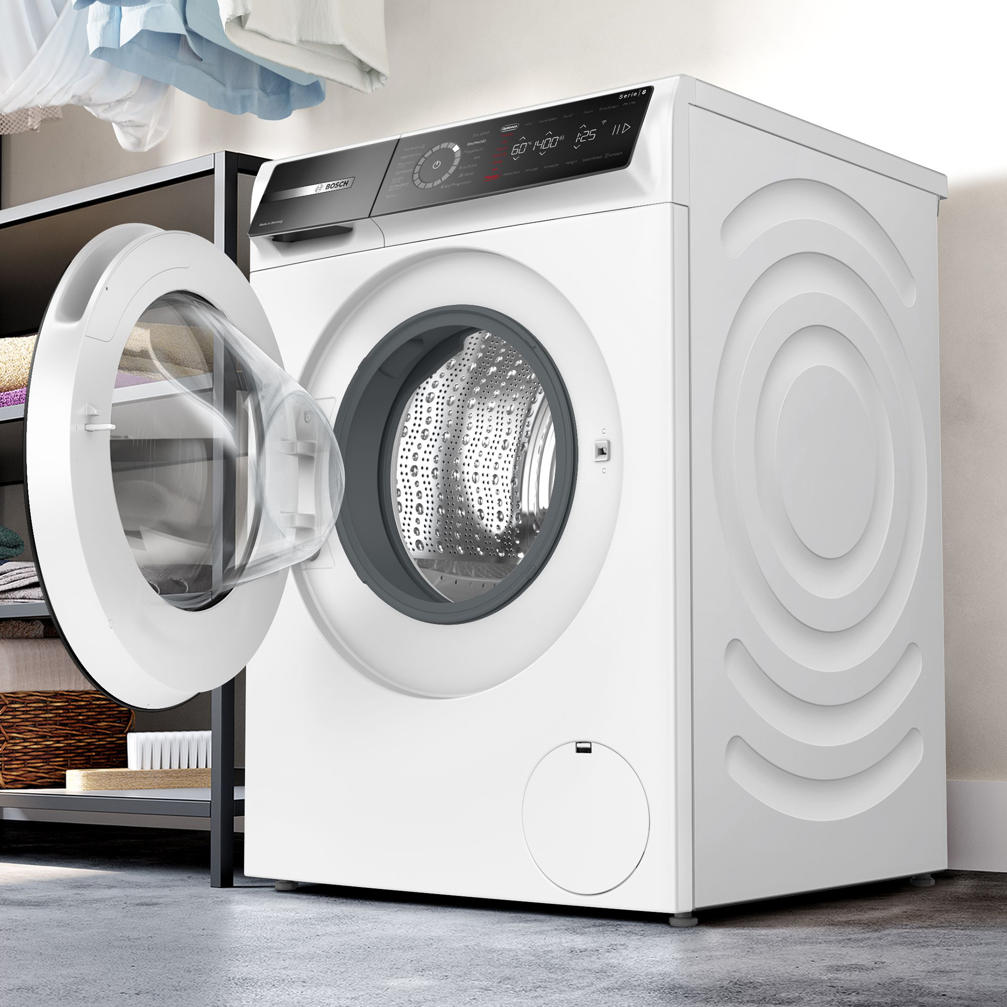 Eine weiße Bosch-Waschmaschine mit geöffneter Trommeltür steht in einem Raum, neben einem Regal mit gefalteter Wäsche.