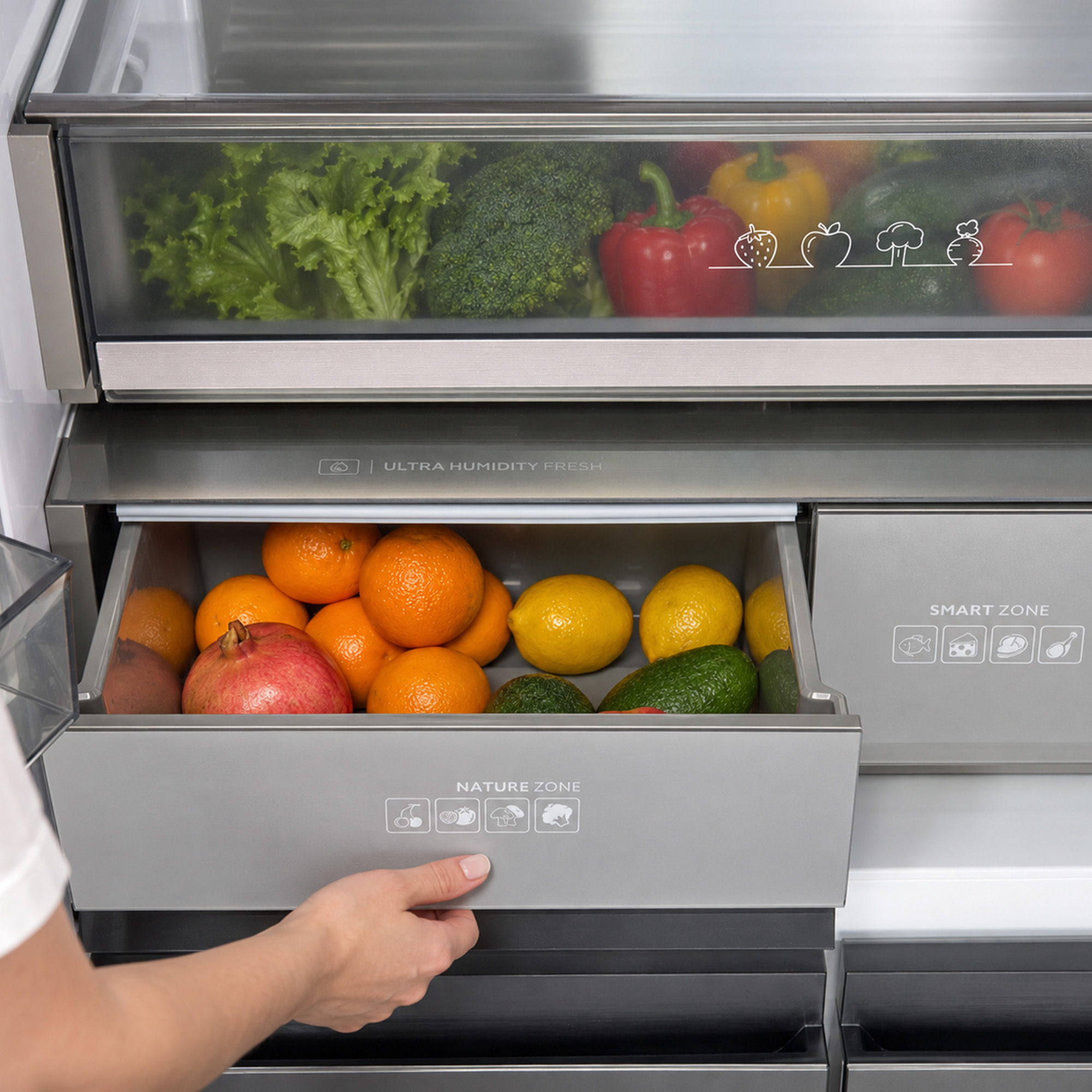 Open refrigerator crisper drawer with fresh fruits and vegetables like oranges, lemons, and lettuce.
