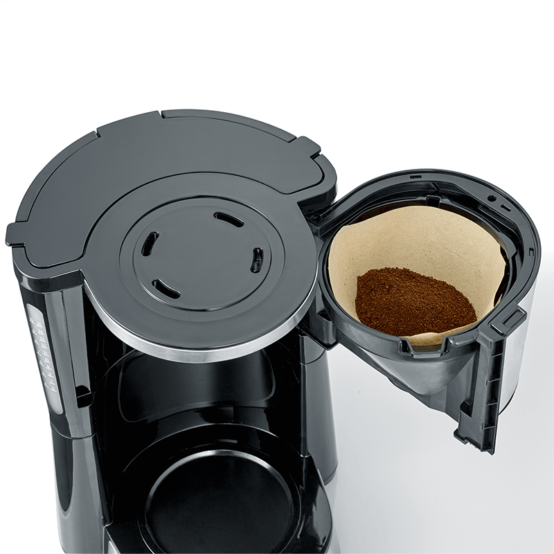 Una macchina da caffè nera con portafiltro aperto contenente caffè macinato.