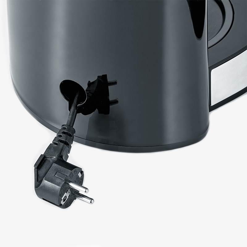 Un cavo di alimentazione nero con spina pende da una macchina da caffè nera.