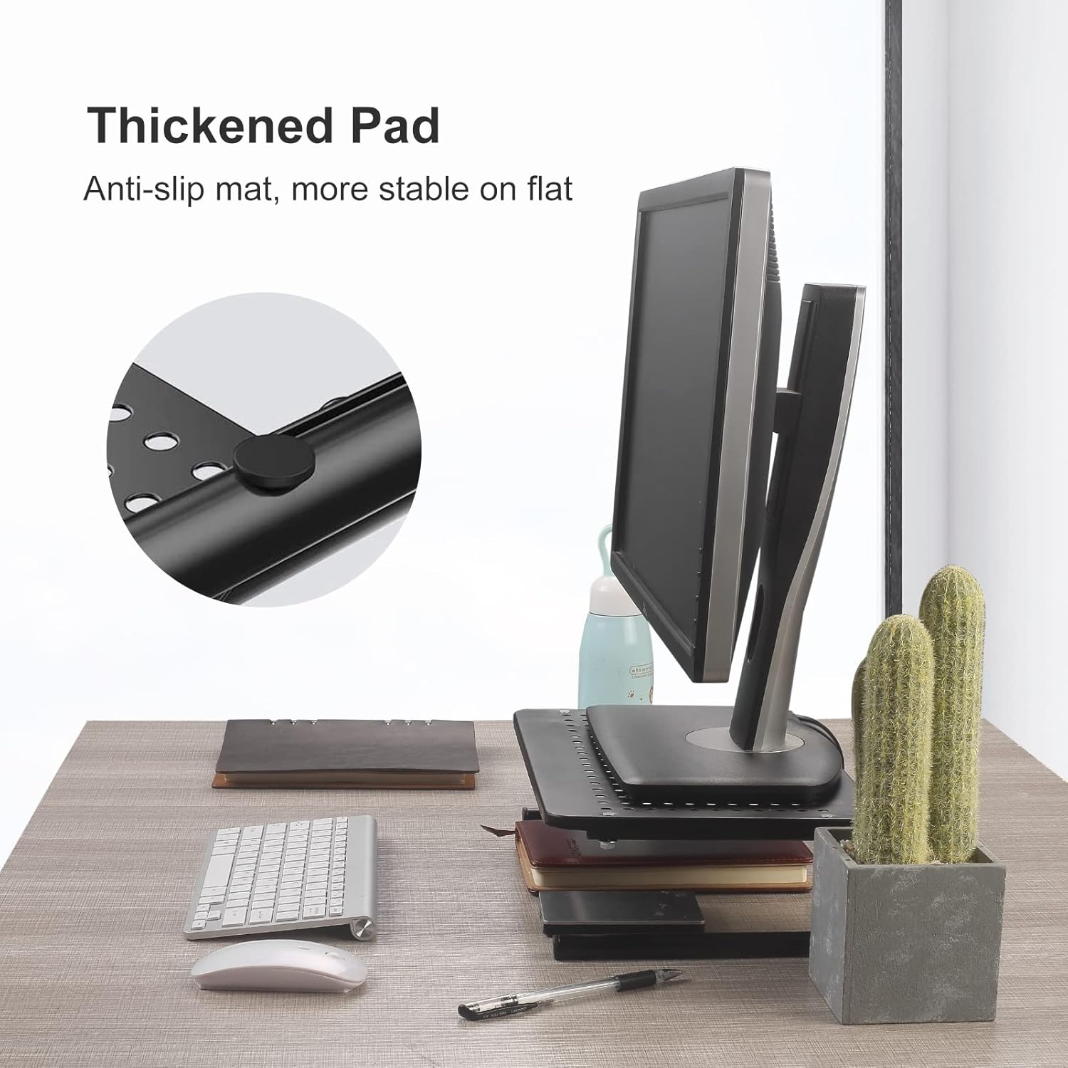 Ein Computermonitor steht auf einem Ständer mit einer Nahaufnahme des Anti-Rutsch-Pads. Tastatur, Maus und Kakteen auf dem Schreibtisch.