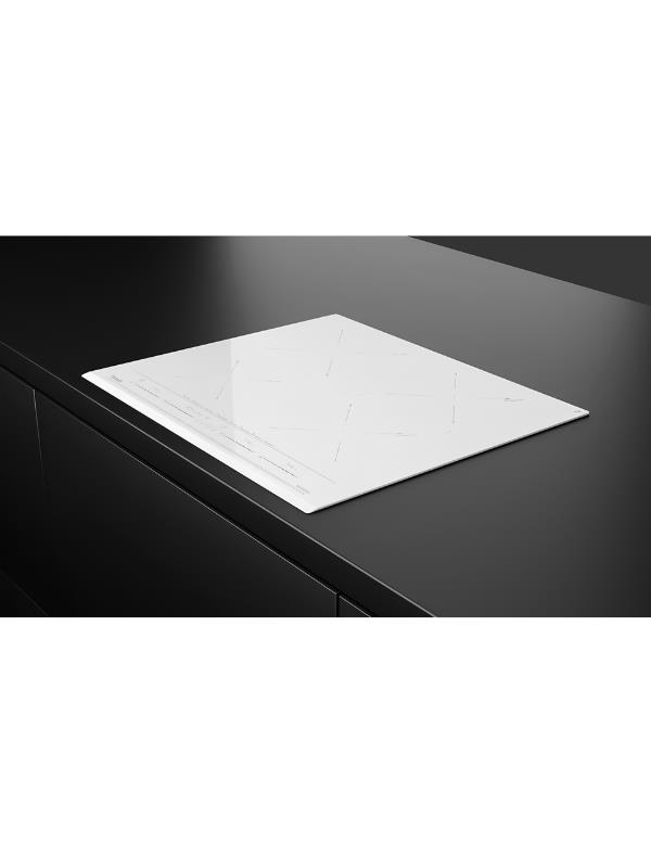 Una placa de inducción blanca está integrada en una encimera oscura.