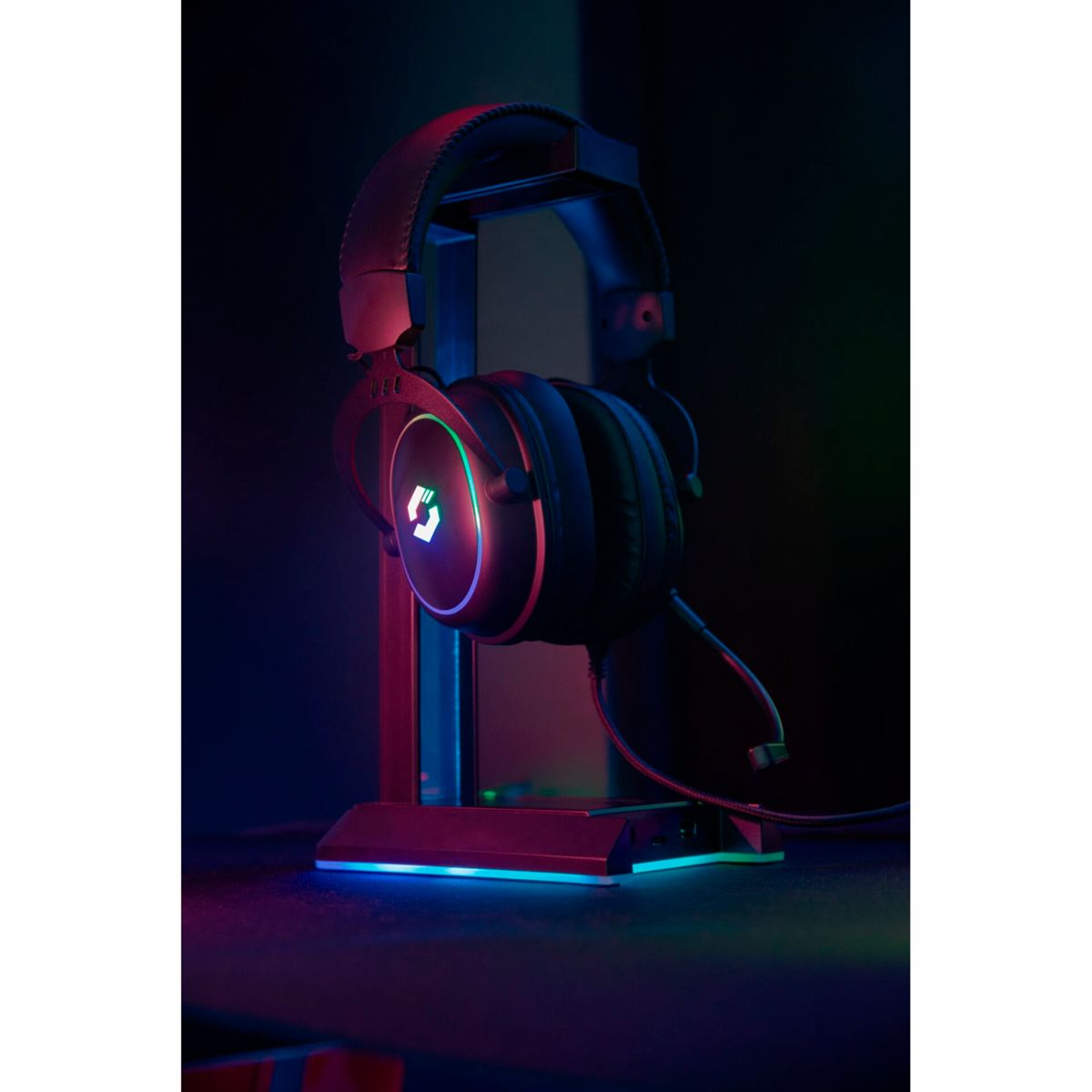 Gaming-Headset auf einem Ständer mit leuchtenden LEDs in einem dunklen Raum.