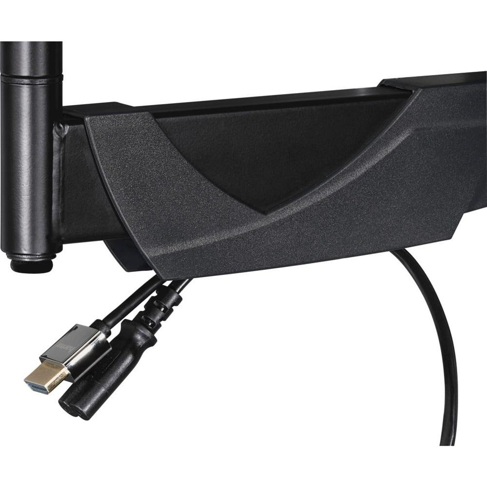 Un soporte de monitor negro con gestión de cables integrada, sosteniendo un cable HDMI y otro cordón.